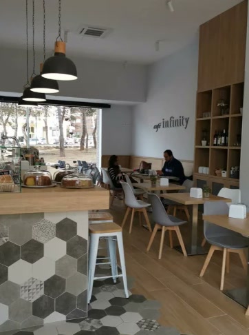 Sala de Café Infinity con mesas de madera y lámparas colgantes